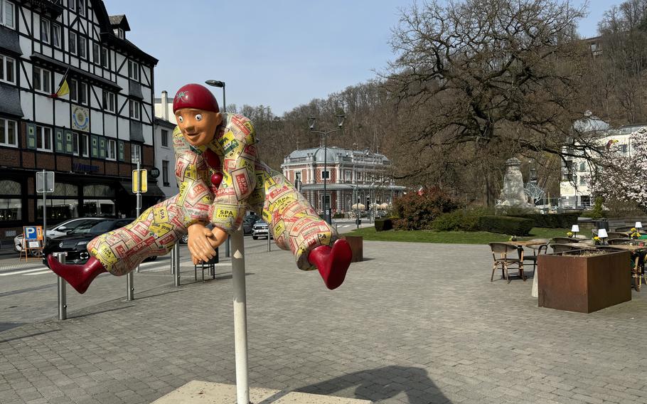 Colorful statue of a man jumping over a pole. One of 12 Pierrot sculptures across the city.
